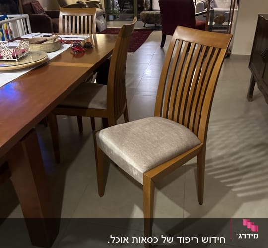 כיסא עץ עם ריפוד בהיר ליד שולחן עץ
